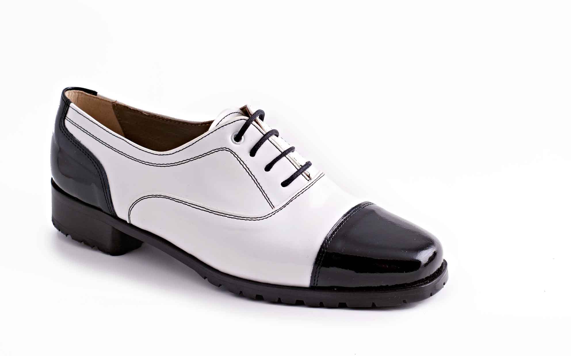 Zapato Chrarlí, fabricado en charol negro y blanco.